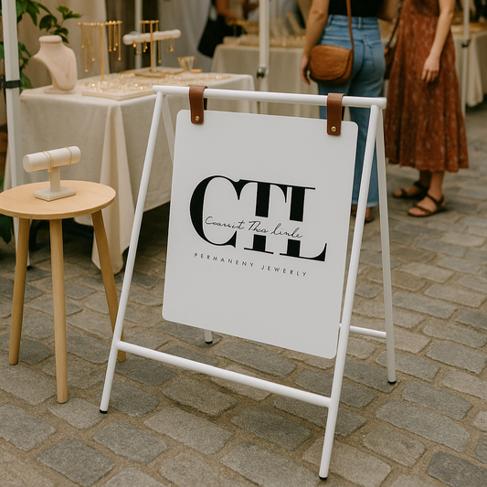 Outdoor event with 'CTI' jewelry stand and people browsing.