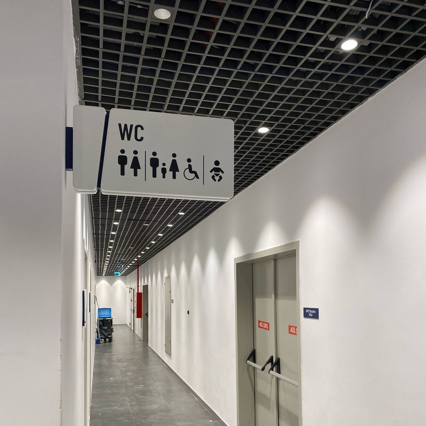 Corridor with a 'WC' sign indicating restroom facilities.