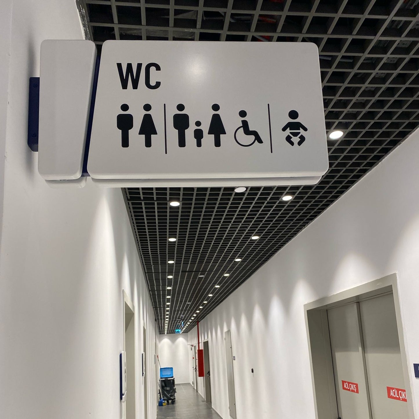 Corridor with a disabled toilet sign above a door