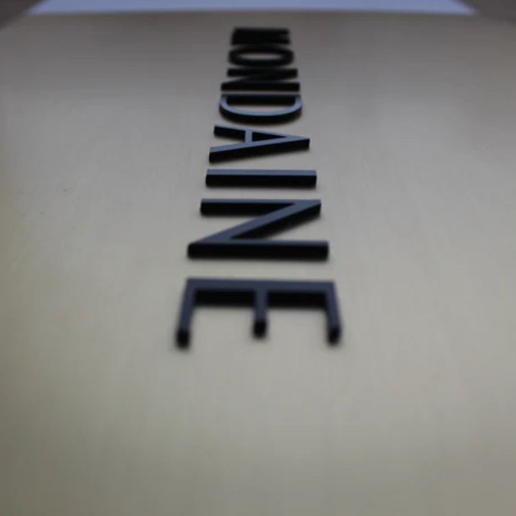 Close-up of a beige surface with 'Mondaine' branding.