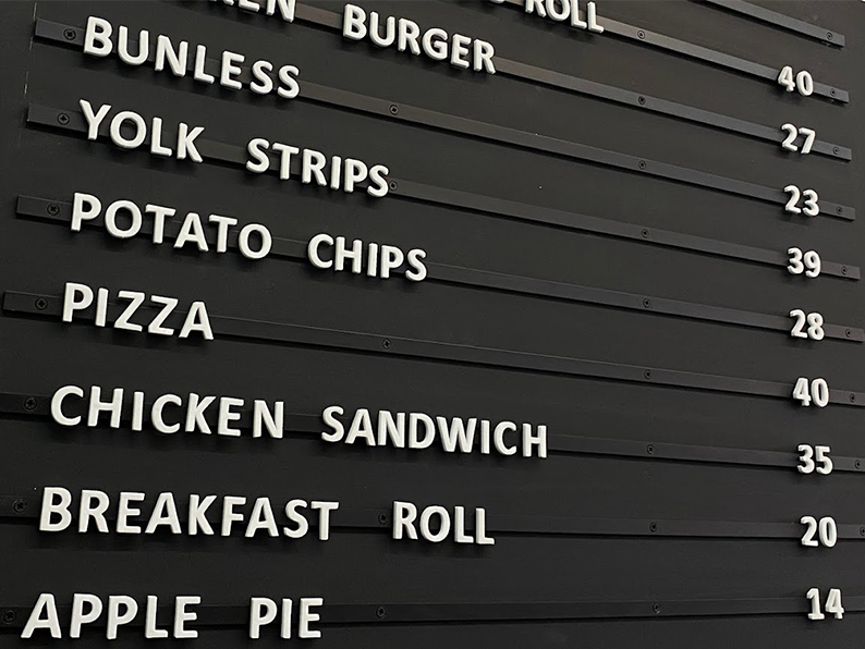 Magnetic menu board with repositionable foam letters for café menu updates.
