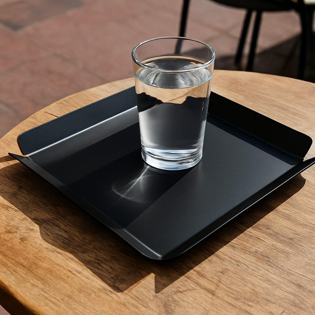 Glass of water on a black tray with a wooden table background