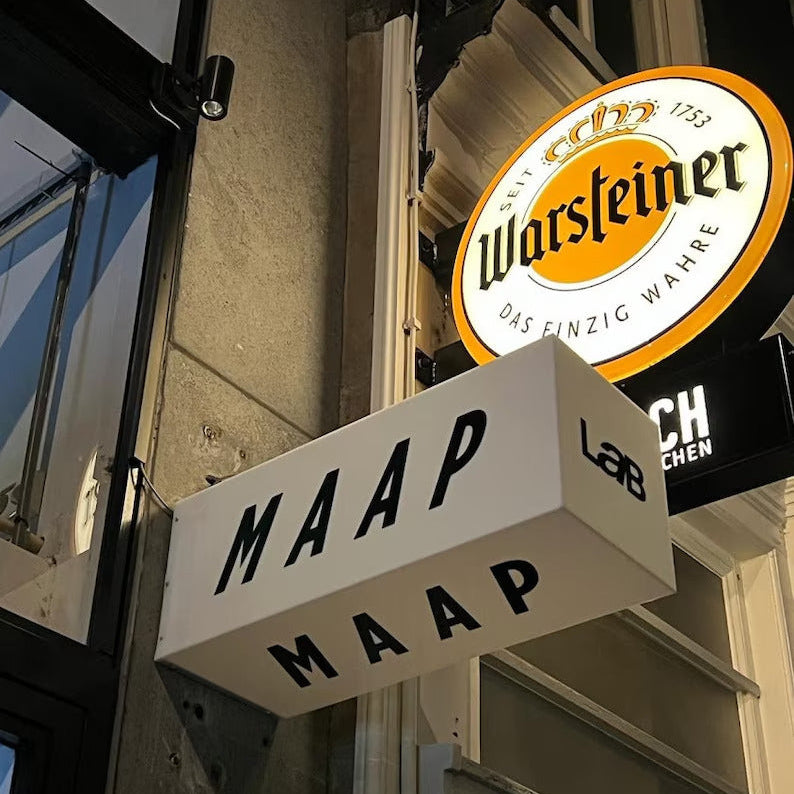 MAAP sign on a building with Warsteiner beer sign above