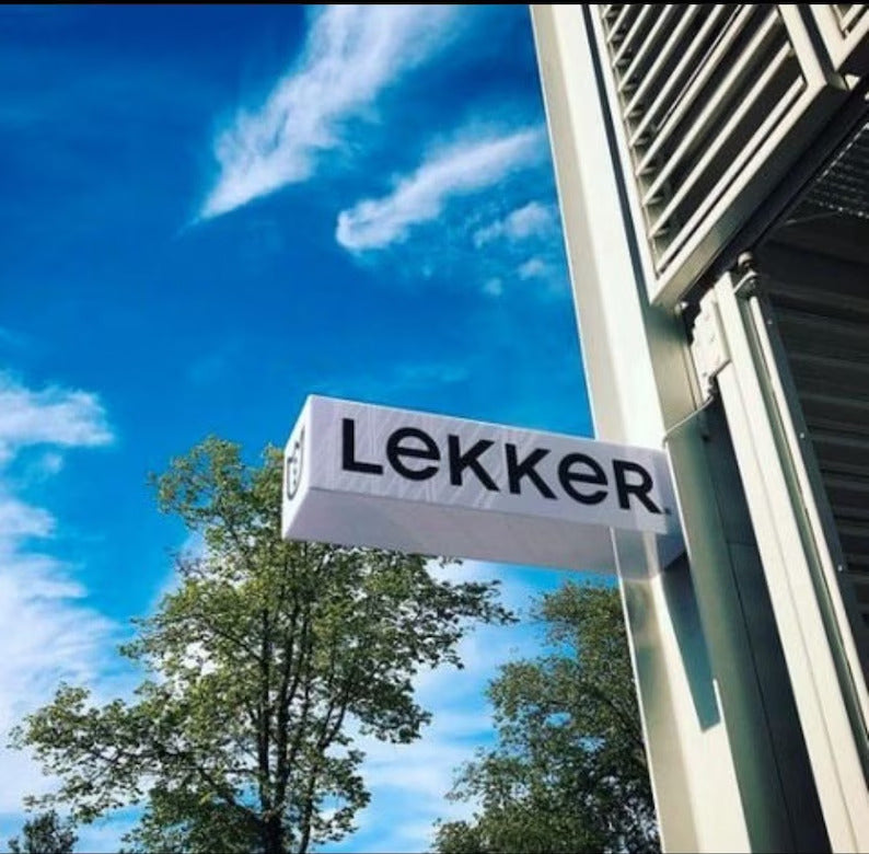 Lekker sign on a building with a blue sky and trees in the background