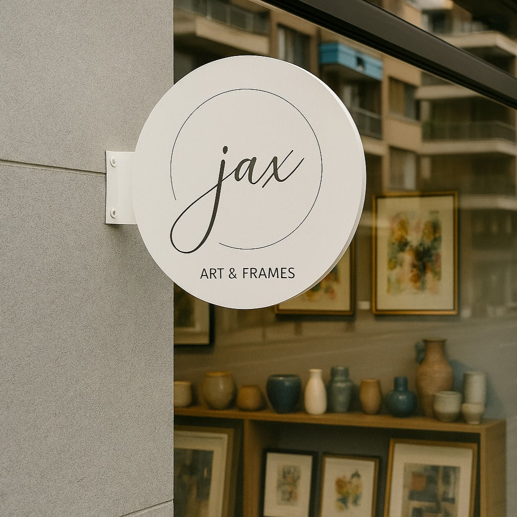 Storefront with 'jax Art & Frames' sign and display of art and frames.