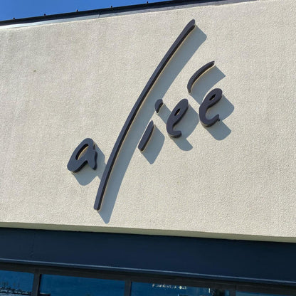 Logo on a building facade with water and dock visible in the reflection