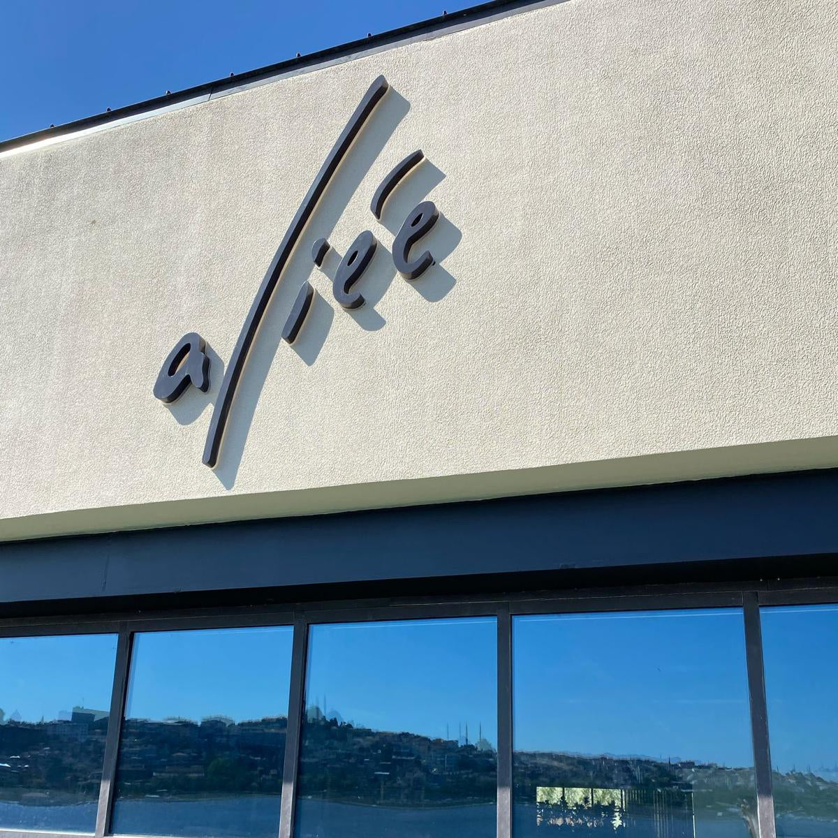 Affe coffee shop exterior with logo and reflection of water and sky.
