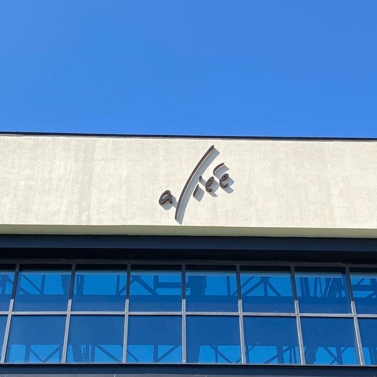 Building facade with a logo against a blue sky