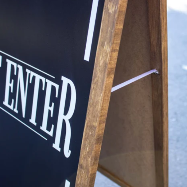 Wooden sign with 'Do Not Enter' text on a reflective surface