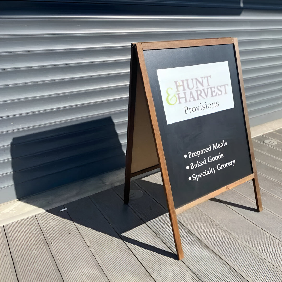 Outdoor sign for Hunt & Harvest Provisions on a wooden deck.