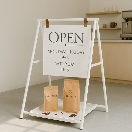 Open sign on a stand with coffee bags and scattered beans in a coffee shop setting