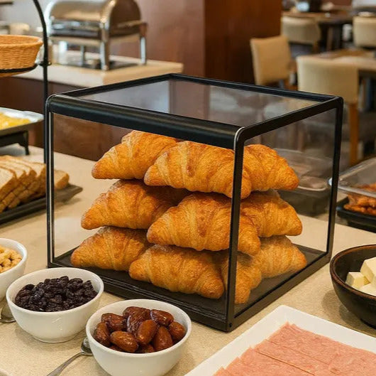 Breakfast buffet with croissants, bread, and other items in a restaurant setting.