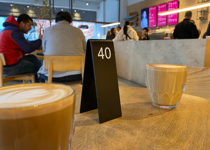"Custom-made double-sided table numbers, personalized with logo printing and QR code options. Ideal for small businesses, cafes, and boutique shops."

