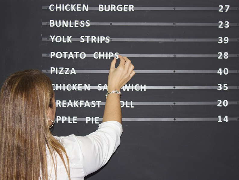 Changeable magnetic letter menu board mounted on a wall.