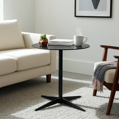Black side table with a white mug, books, and a small plant in a living room setting.
