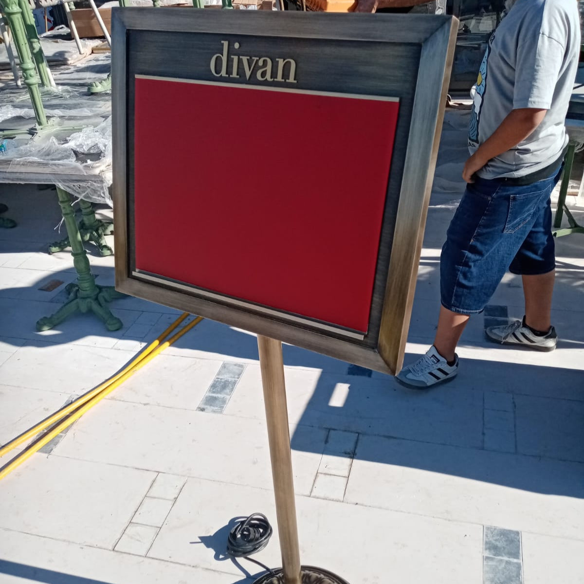 Outdoor setting with a sign labeled 'divan' on a stand.