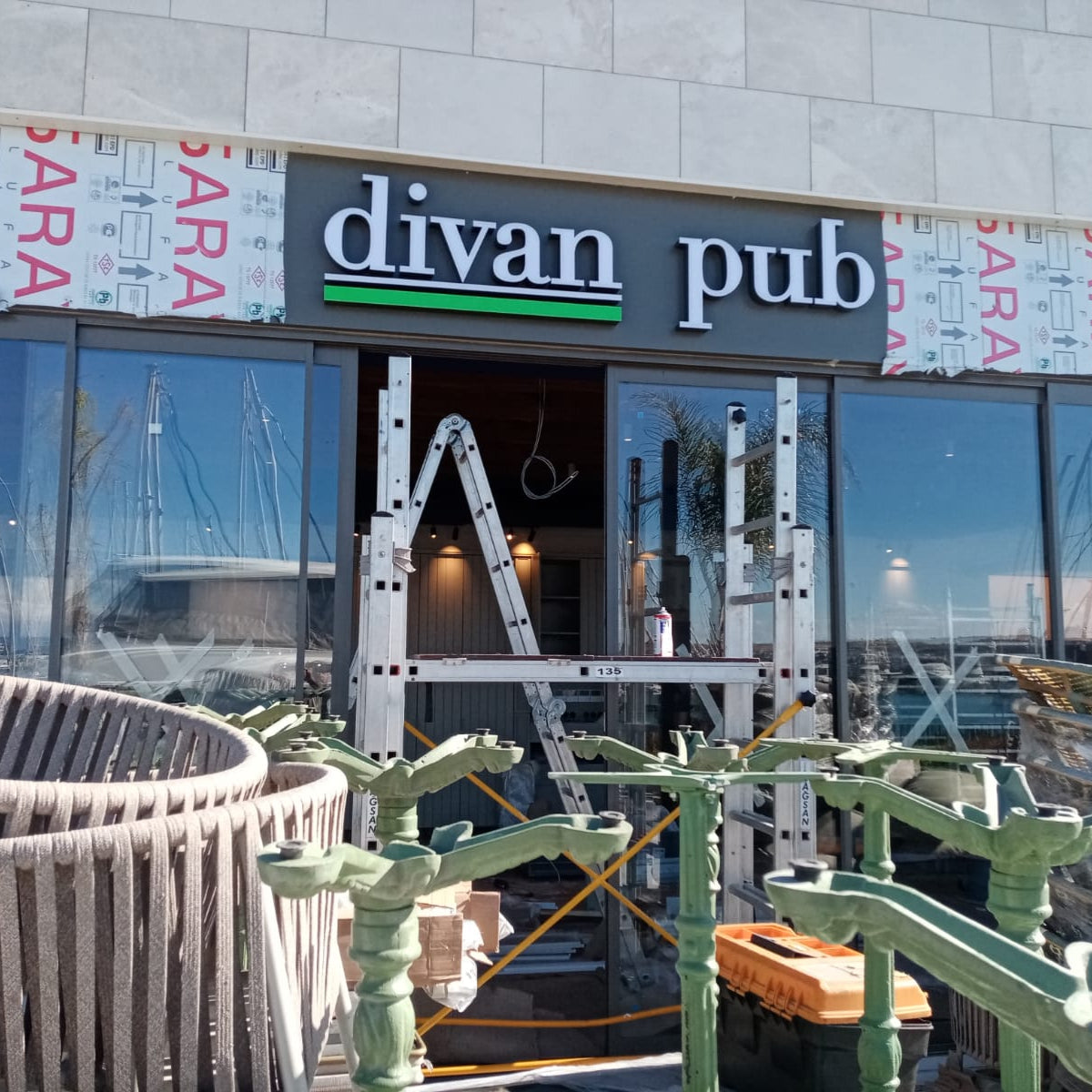 Divan Pub establishment with outdoor seating area and construction scaffolding.