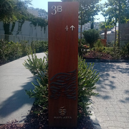 Orange directional sign with '3B' and '4' arrow in a garden setting