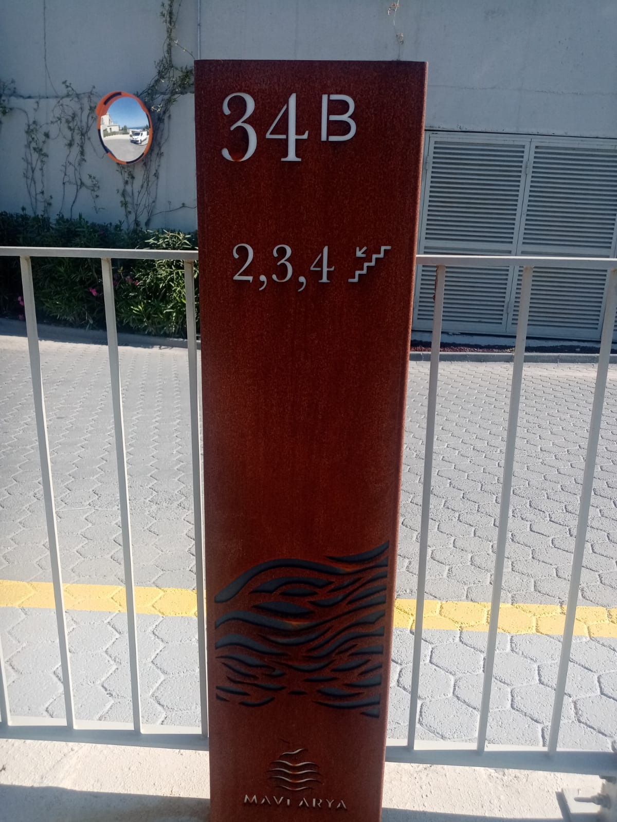 Tall red sign with '34B' and '2,3,4' on a white wall background