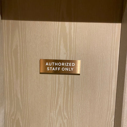 Beige door with a gold 'Authorized Staff Only' sign
