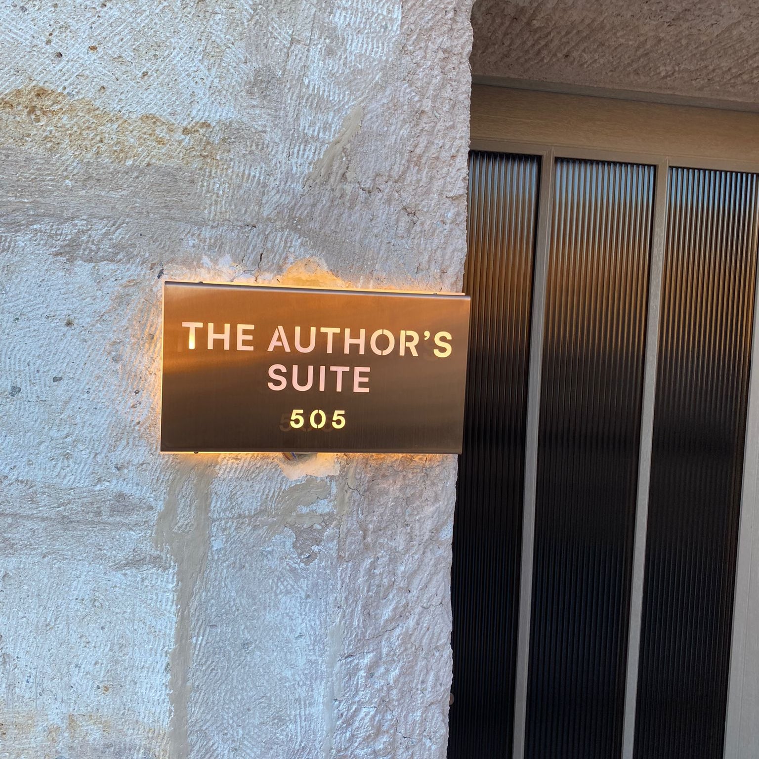 Bronze plaque on a stone wall indicating 'The Author's Suite 505'.