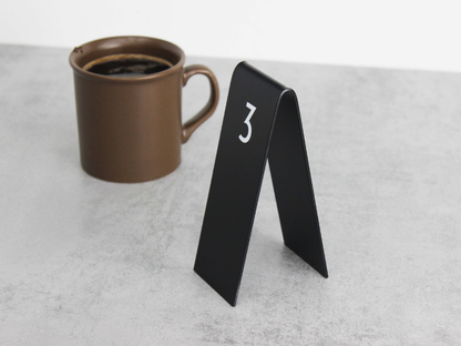 Double-sided Custom Table Number Stackers designed for weddings, cafes, and restaurants. Available with QR code printing and customizable in metal or wood to match any business aesthetic.