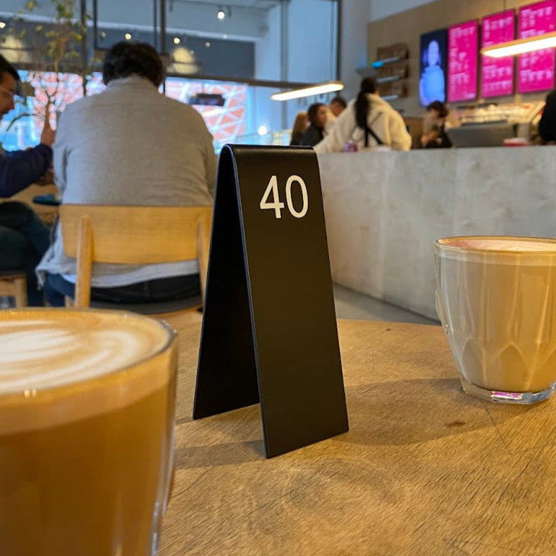 "Custom-made double-sided table numbers, personalized with logo printing and QR code options. Ideal for small businesses, cafes, and boutique shops."

