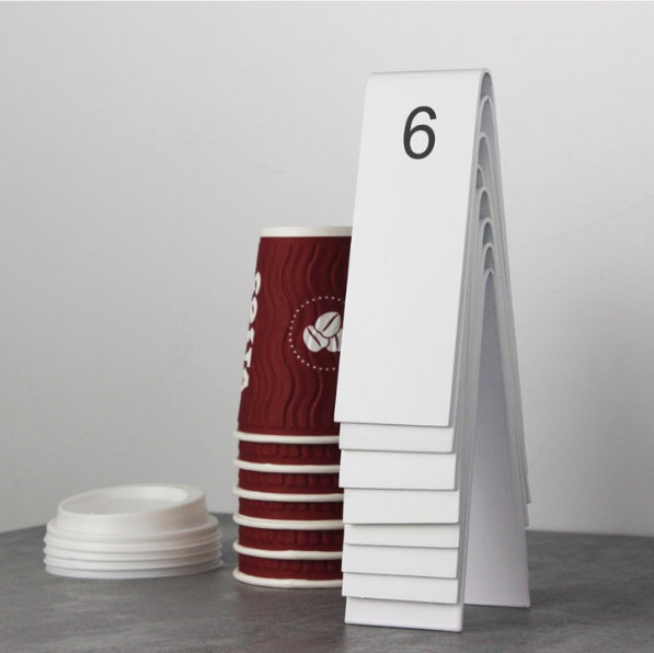 "Double-sided personalized table numbers designed for weddings, cafes, and restaurants. Available with QR code printing and customizable in metal or wood to match any business aesthetic."


