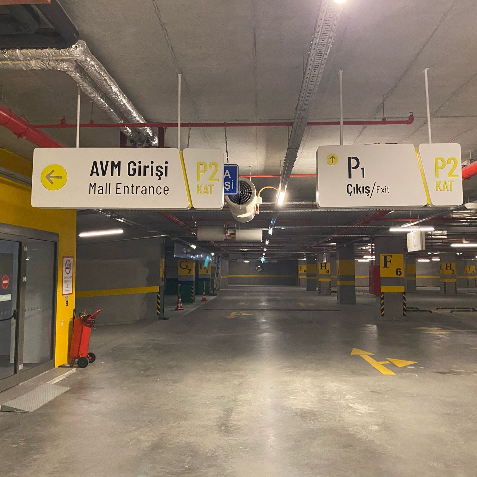Parking garage interior with directional signs indicating AVM entrance and exits.