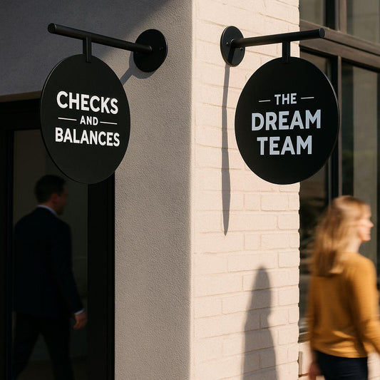 Two round signs on a building wall, one labeled 'Checks and Balances' and the other 'The Dream Team'.