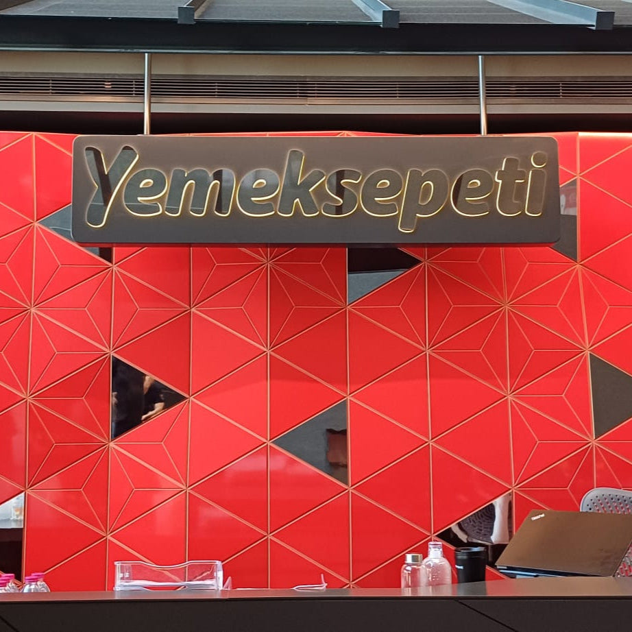Red geometric-patterned wall with 'Yemeksepeti' branding