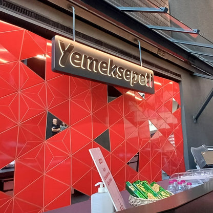 Red geometric wall with 'Yemeksepeti' sign inside a building