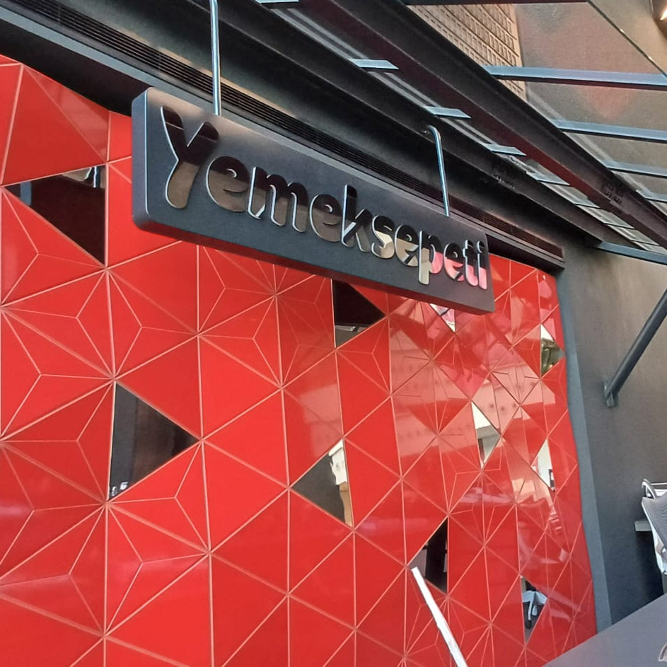 Red geometric-patterned wall with a 'Yamask' sign above a store entrance.