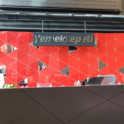 Red geometric patterned wall with 'Yemeksepeti' branding above a counter.