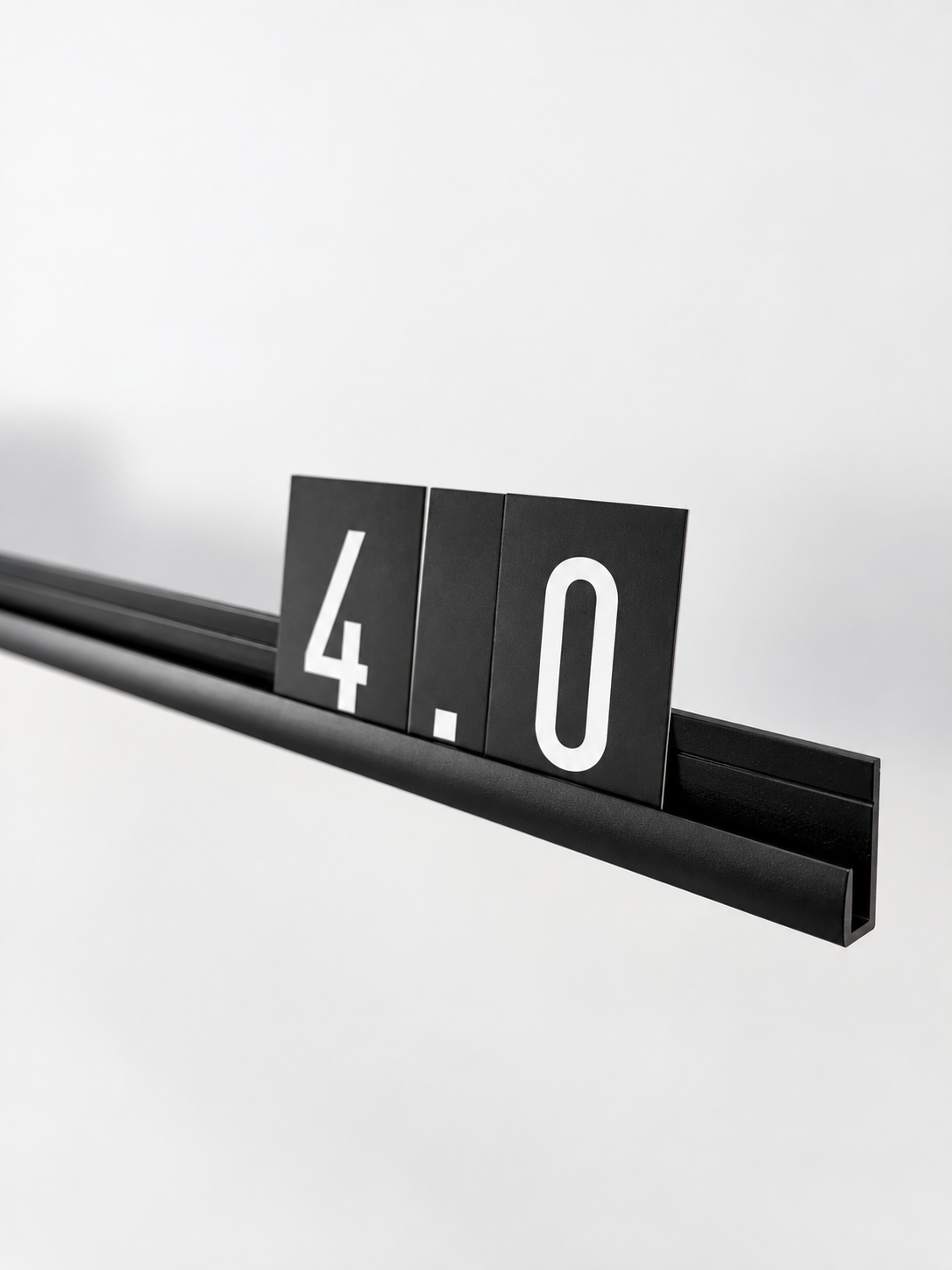 Close-up of black aluminum letter board rail profile with interchangeable number cards