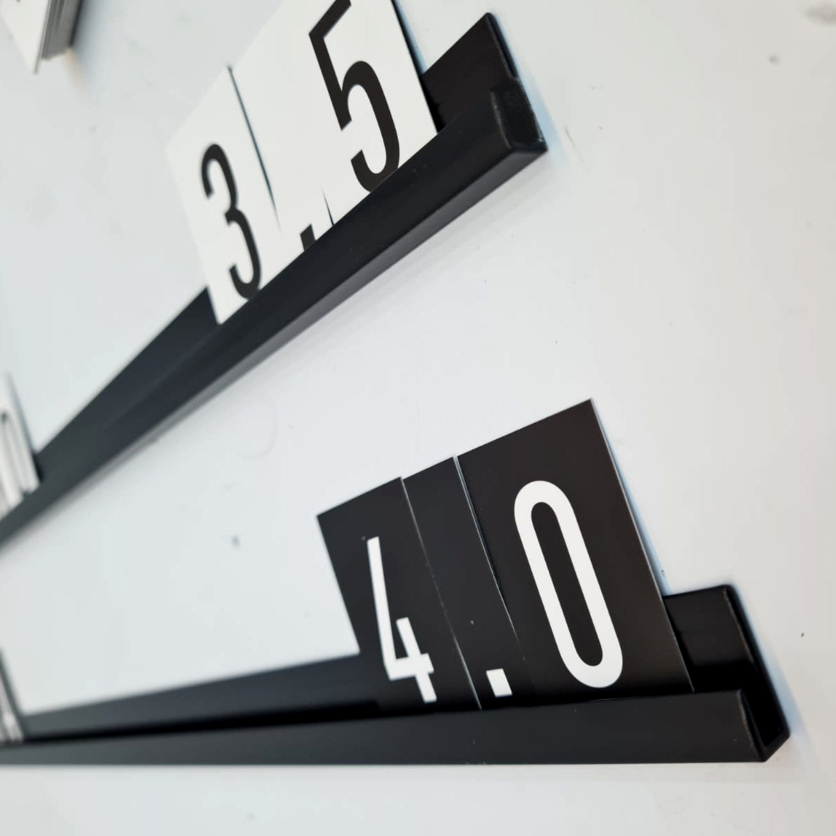 Close-up of black interchangeable menu board rails with black 4.0 cards and white 3.5 cards