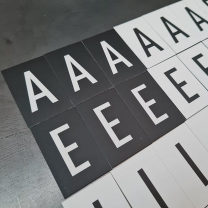 Alphabet tiles with letters 'A', 'E', and 'I' on a wooden surface