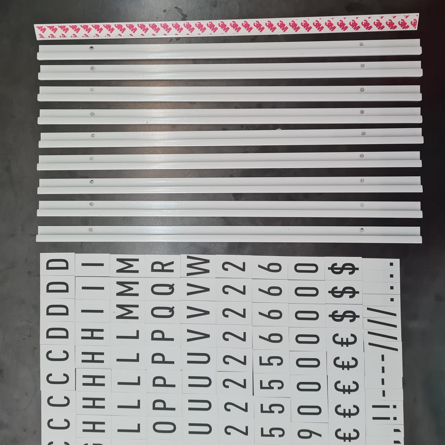 Set of metal strips with printed characters on a dark surface