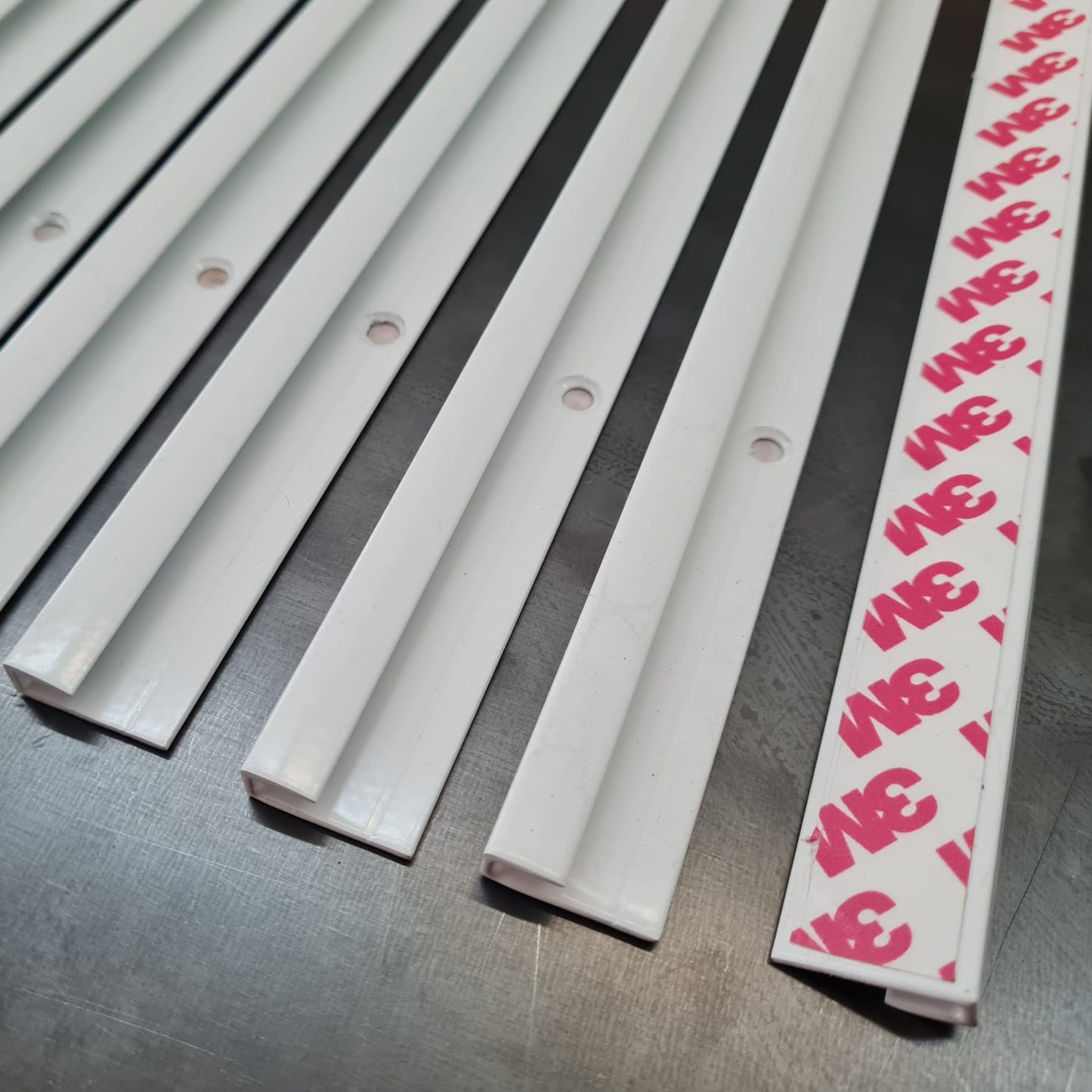 Metallic strip with pink and red pattern on a metallic surface