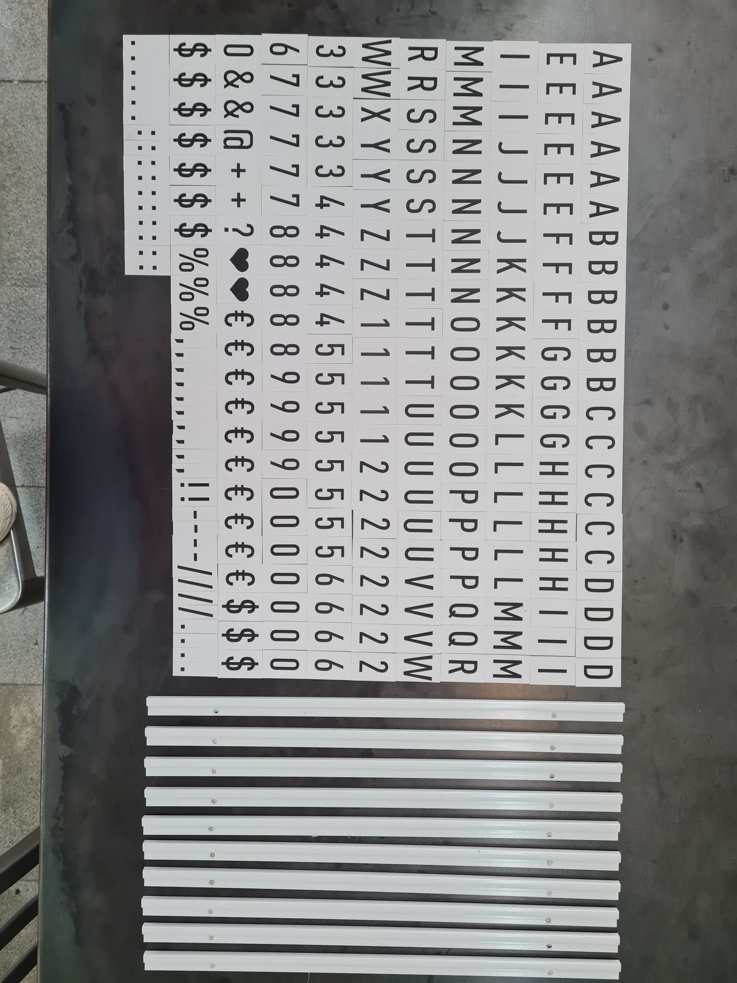 Set of metal letters and symbols on a metallic surface