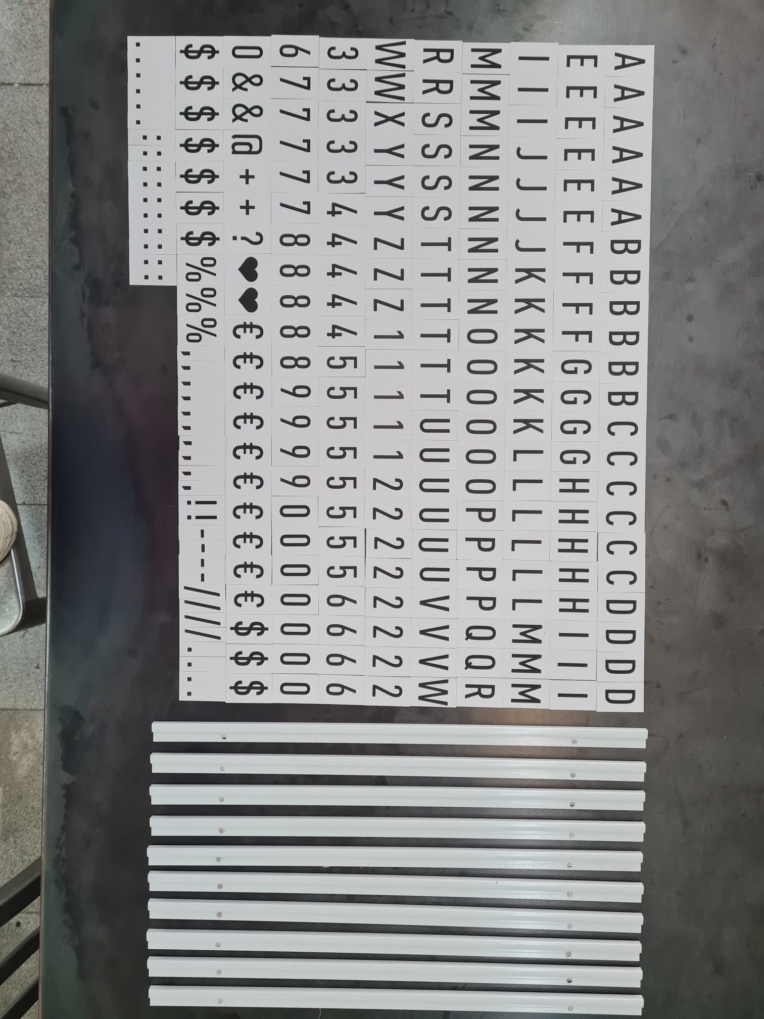 Set of metal letters and symbols on a metallic surface