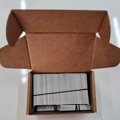 Open brown cardboard box containing a stack of white cards on a white background