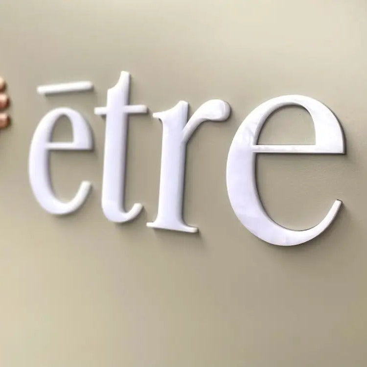 White 'etre' logo on a beige background
