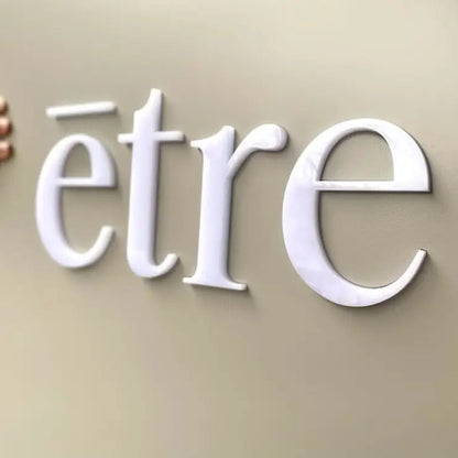 White 'etre' logo on a beige background