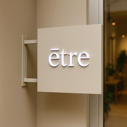 Beige sign with 'etre' on a wall inside a building
