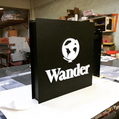 Black box with 'Wander' logo on a cluttered workbench