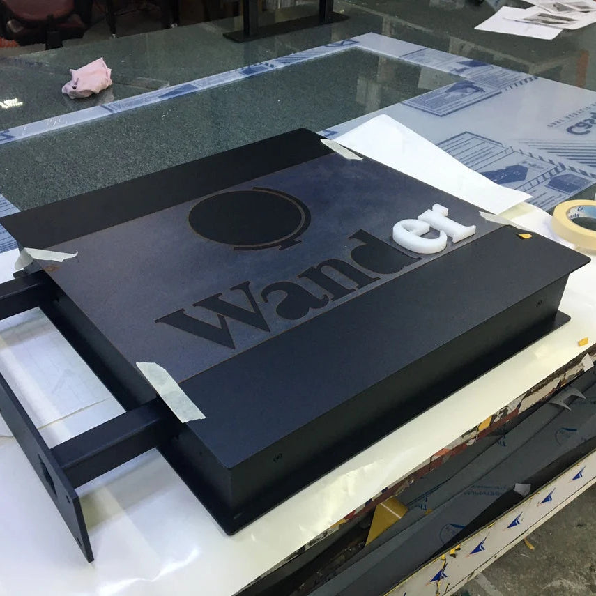 Black electronic device with 'Wand' branding on a table with packaging materials.