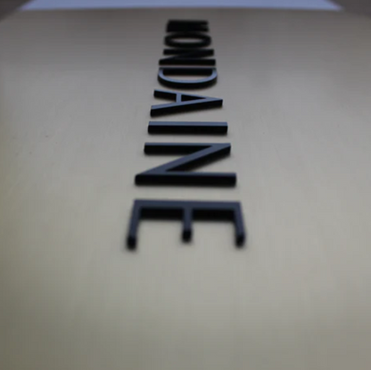 Close-up of a beige surface with 'Mondaine' branding.