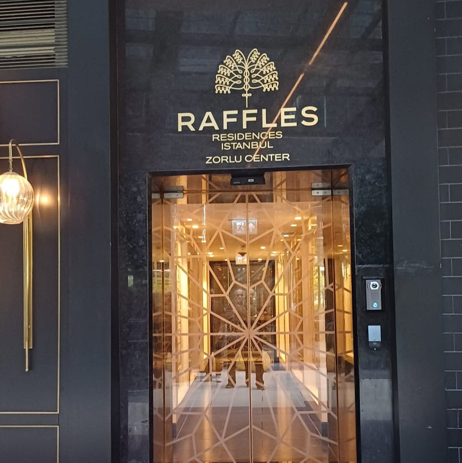 Raffles hotel entrance with glass door and logo