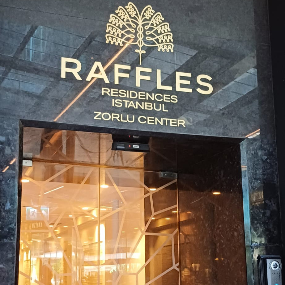 Entrance to Raffles Residences Istanbul with decorative glass door.